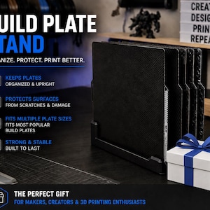 May include: A black build plate stand with multiple slots, designed to hold and protect plates. The stand has text that reads "BUILD PLATE STAND" and "ORGANIZE. PROTECT. PRINT BETTER."