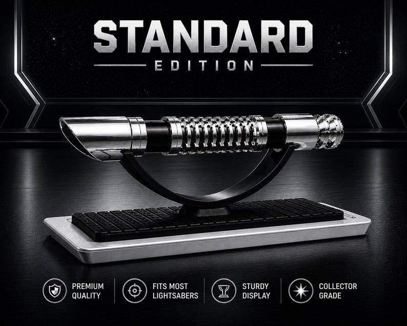 Pode incluir: Uma r&eacute;plica de sabre de luz prateado e preto, rotulada como "STANDARD EDITION", &eacute; exibida em um suporte preto com uma base prateada. O sabre de luz apresenta detalhes intrincados e foi projetado para caber na maioria dos sabres de luz. A imagem inclui &iacute;cones indicando qualidade premium e grau de colecionador.