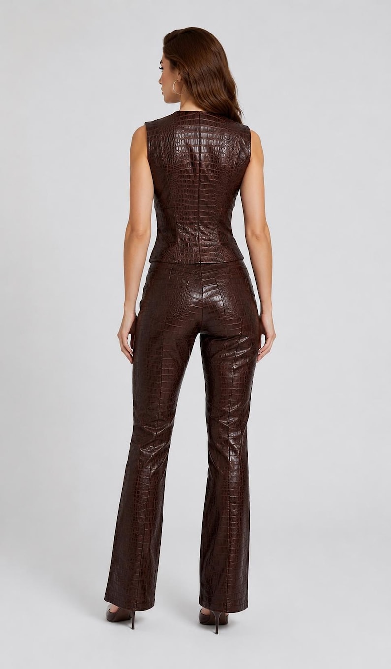 May include: A dark brown sleeveless vest and matching long trousers set featuring a textured crocodile skin pattern. The vest has a fitted silhouette with a back zipper closure, and the trousers are straight-legged with a high-waisted design.