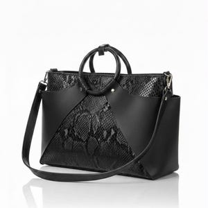 May include: A black handbag featuring a textured snakeskin pattern on the main body and smooth black panels on the front. The bag includes two circular top handles and a detachable shoulder strap attached with silver-toned metal hardware.