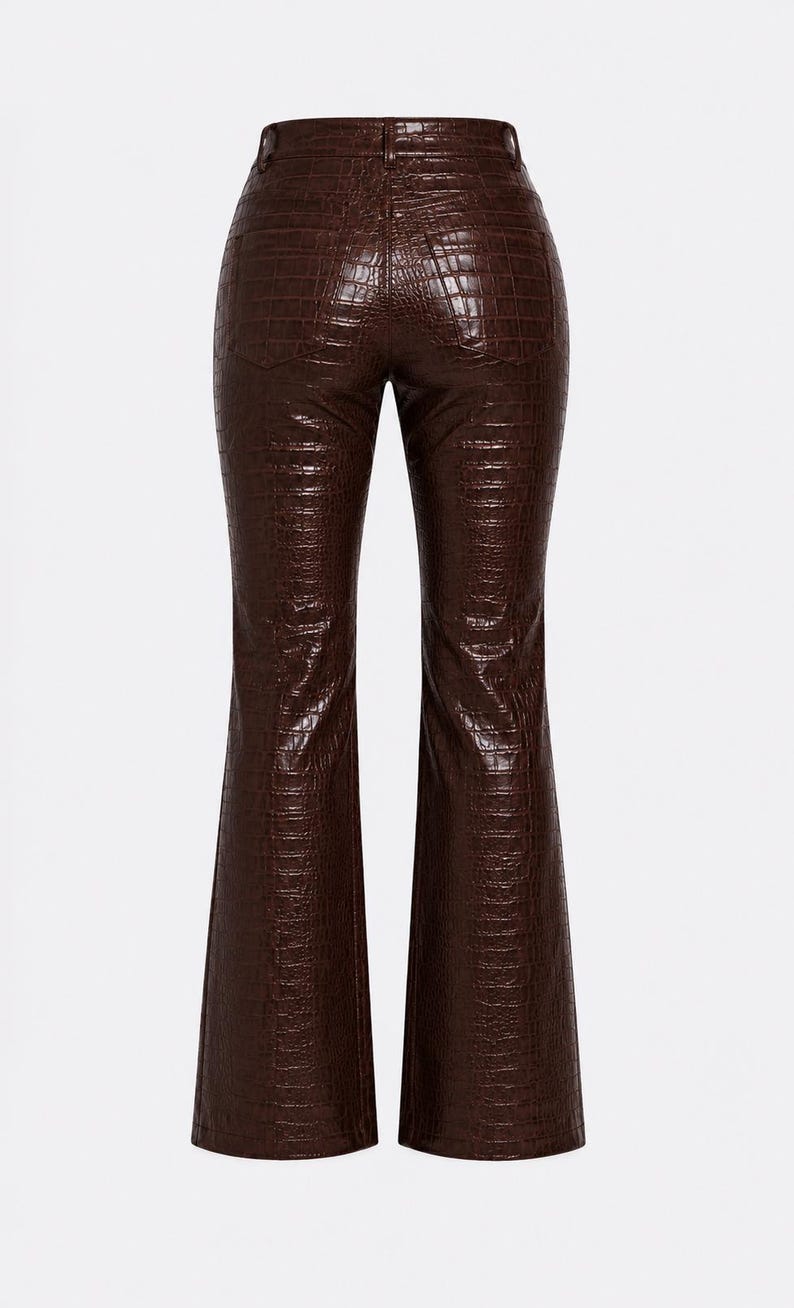 May include: Dark brown trousers featuring a glossy finish and a textured crocodile skin pattern. These pants have a high-waisted design with a button closure, belt loops, and a flared leg silhouette that widens towards the bottom hem.