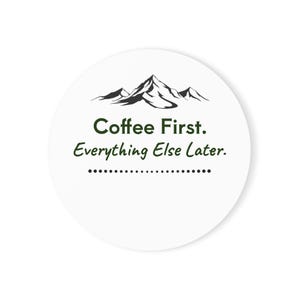 May include: A circular white sticker featuring a black mountain range graphic at the top. Below the mountains, the text reads "Coffee First. Everything Else Later." in dark green lettering, followed by a horizontal line of small black dots.