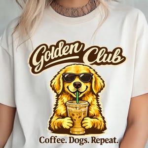 Könnte beinhalten: Cremefarbenes T-Shirt mit einem Cartoon-Golden Retriever, der eine Sonnenbrille trägt und Eiskaffee trinkt. Der Text "Golden Club" ist über dem Hund gewölbt, darunter steht "Coffee. Dogs. Repeat."