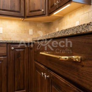 Puede incluir: Una taza de cerámica blanca con asa negra y el texto "But First, Coffee" en negrita negra. La taza se encuentra sobre un fondo borroso, sugiriendo un ambiente acogedor.