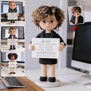 Pode incluir: Boneca de crochê de uma mulher com cabelo encaracolado, óculos e roupa preta, segurando uma placa branca. A placa diz "Jessia, Caso ninguém lhe tenha dito hoje... Você é incrível, Você é importante, Você faz a diferença, Você é incrivelmente APRECIADA."