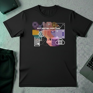 May include: Black t-shirt with a colorful graphic design featuring computer-related icons and the text "SELF-HOSTING EVERYTHING" in white. The design includes a circuit board, a play button, a lock, a graph, a server, and a cloud.