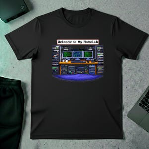 Puede incluir: Camiseta negra con un gráfico pixelado de un laboratorio informático con tres monitores, un escritorio y bastidores de servidores. El texto "Welcome to My Homelab" está encima de los monitores.