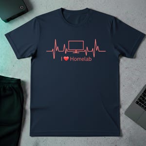 Puede incluir: Camiseta azul marino con un diseño de línea de latido cardíaco rojo que presenta un monitor de computadora y el texto "I ❤️ Homelab". El diseño está centrado en la parte delantera de la camiseta.