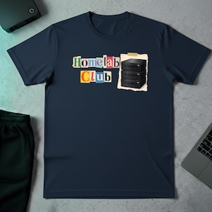 Op de afbeelding: Marineblauw t-shirt met de tekst "Homelab Club" in een kleurrijke, uitgesneden stijl. Een afbeelding van drie zwarte servereenheden staat rechts. Het shirt is gemaakt van een zacht materiaal.