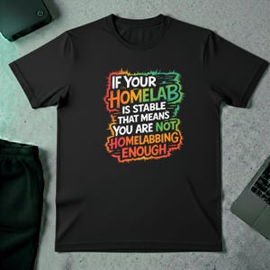 Peut inclure: T-shirt noir avec l'inscription "IF YOUR HOMELAB IS STABLE THAT MEANS YOU ARE NOT HOMELABBING ENOUGH" dans une police colorée et vieillie. Le t-shirt est posé à plat sur une surface texturée.