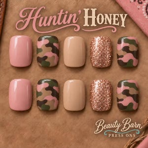 Op de afbeelding: Een set van tien press-on nagels met de tekst Huntin' Honey en Beauty Barn Press Ons. De nagels bevatten effen lichtroze, effen beige, camouflagepatronen in roze, olijfgroen en bruin, en afwerkingen met roségouden glitters.