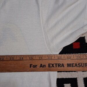 K&ouml;nnte beinhalten: Handgefertigtes Holzschild mit dem handgeschriebenen Wort "Welcome". Das Schild ist wei&szlig; lackiert mit einem Used-Look und einem dekorativen Blumendesign. Zum Aufh&auml;ngen an Wand oder T&uuml;r.