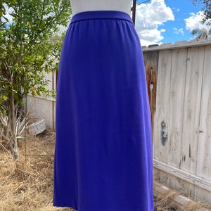 May include: A long, purple skirt with a straight cut and a simple waistband.