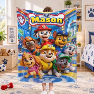 May include: A rectangular fleece blanket featuring a colorful graphic of the Paw Patrol characters and the name Mason in large yellow letters at the top. The design includes Marshall, Chase, Rubble, Skye, Rocky, and Zuma on a blue background.