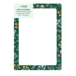 May include: A blank notepad with a dark green border adorned with colorful floral illustrations. The notepad has a white interior and the text "WILD FLOWERS" and "BLANK NOTEPAD 5X7 | 50 pages" are displayed in the upper left corner.