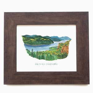 May include: Watercolour painting of the Columbia River Gorge in a dark brown wooden frame. The artwork depicts a river winding through a landscape of green trees, mountains, and cliffs. The text "COLUMBIA RIVER GORGE" is at the bottom.