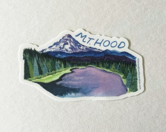May include: A sticker featuring a watercolor illustration of Mt. Hood, a snow-capped mountain, with a lake and evergreen trees. The text "M.T. HOOD" is written in blue above the mountain. The sticker has a white border and a light background.