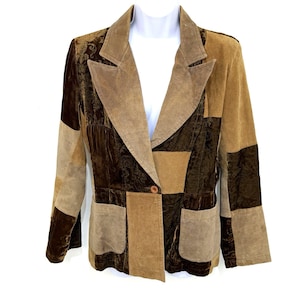 May include: A patchwork blazer featuring alternating panels of dark brown velvet with a subtle tonal damask pattern and light tan suede. The garment includes wide lapels, a single front button closure, and two rectangular patch pockets at the waist.