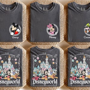 May include: Six charcoal gray t-shirts with Disney character designs. Three shirts feature Mickey and Minnie Mouse with text reading "Daddy", "Mommy", and "Custom Name". The other three shirts display a Disney World graphic with the text "Disneyworld 1971".