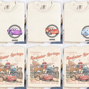 Puede incluir: Camisetas de color crema con gr&aacute;ficos de coches de dibujos animados dentro de un c&iacute;rculo a cuadros, con la palabra "NAME" debajo. Las camisetas inferiores muestran un gr&aacute;fico de estilo vintage de "Radiator Springs" con varios personajes de coches.