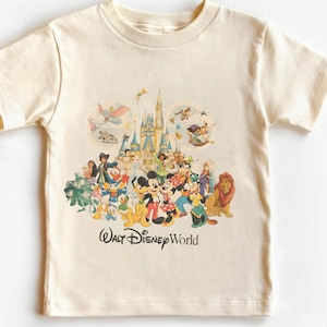 May include: Cream-colored t-shirt featuring a colorful graphic of Disney characters, including Mickey and Minnie Mouse, Donald Duck, and Simba. The image includes a castle and the text "Walt Disney World".