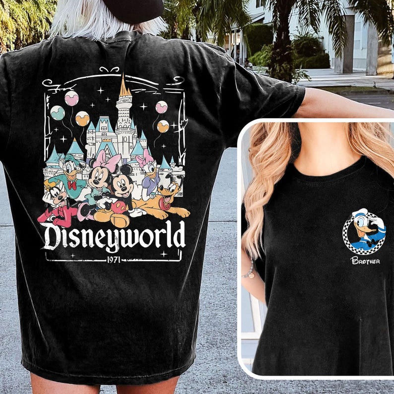 May include: Black t-shirt featuring a Disney World graphic on the back with Mickey, Minnie, Donald, Daisy, Goofy, and Pluto. The front of the shirt has a small circular graphic of Donald Duck with the word "Brother" below.