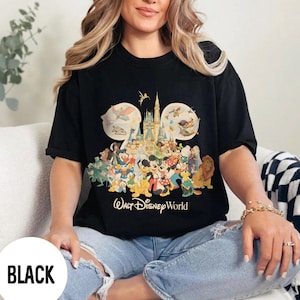 May include: Black t-shirt featuring a colorful graphic of Disney characters, including Mickey Mouse, Donald Duck, and others, with the text "Walt Disney World." The design includes a castle and the number 50. The word "BLACK" is in a white box.