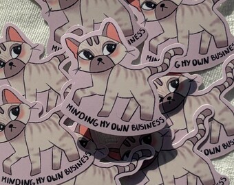 May include: A collection of cat stickers with a light grey and white color scheme. Each sticker features a cartoon cat with the text "Minding My Own Business". The stickers are arranged on a white surface.