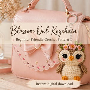 Könnte beinhalten: Eine rosa Handtasche mit goldenen Details und einem gehäkelten Eulen-Schlüsselanhänger. Die Eule, mit einem Blumenkranz, ist aus braunem, beigem und weißem Garn gefertigt. Der Text auf dem Bild lautet "Blossom Owl Keychain" und "Beginner Friendly Crochet Pattern".