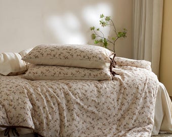 Conjunto de cama de luxo em estilo francês, em algodão e linho com estampa floral marrom e fechos de amarrar.