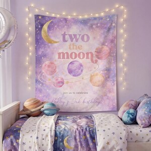 May include: A bedroom scene with a celestial theme. A tapestry with planets and the text "two the moon" hangs above a bed with a star and moon patterned comforter. Decorative pillows and planet-shaped toys complete the look.