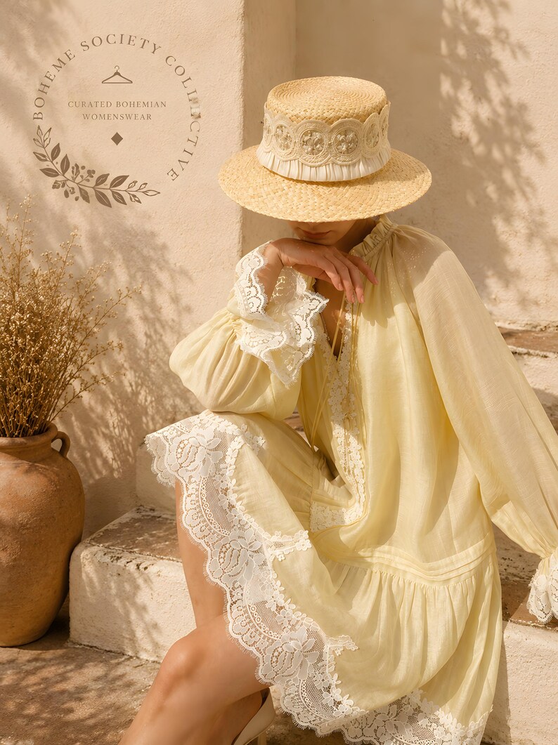 May include: A light yellow long-sleeve dress featuring white lace trim on the cuffs and hem, paired with a straw boater hat adorned with a white lace band. The text Boheme Society Collective Curated Bohemian Womenswear is visible in the corner.