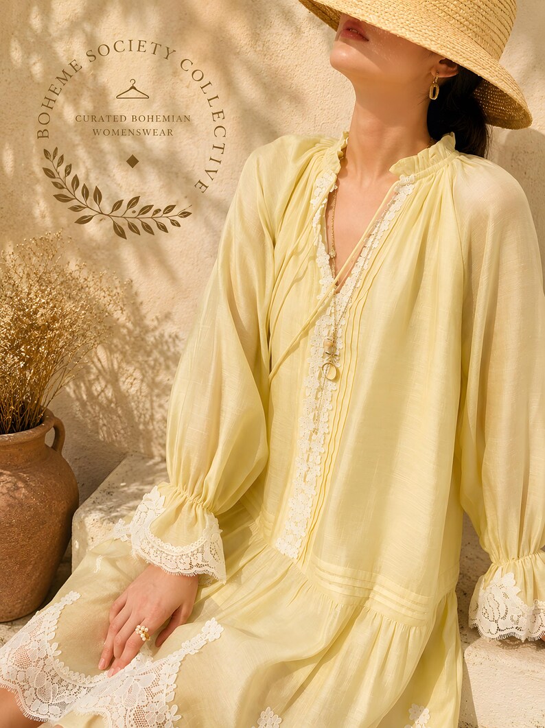 May include: A pale yellow long-sleeved dress featuring a ruffled collar, white lace trim along the front placket, cuffs, and hem, and a straw hat. The text "BOHEME SOCIETY COLLECTIVE CURATED BOHEMIAN WOMENSWEAR" is printed in the upper left corner.