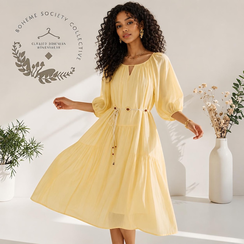Yellow boho midi dress for women featuring lightweight Tencel fabric, romantic puff sleeves, flowing A-line silhouette, and adjustable lace-up waist detail. Feminine cottagecore summer dress with soft airy texture and relaxed fit perfect for brunch dates, vacations, garden parties, tea parties, casual chic styling, and everyday elegance. Pastoral-inspired midi dress in buttery yellow tone designed for breathable comfort and graceful movement during spring and summer wear.