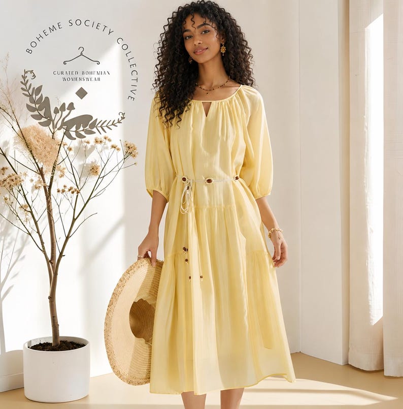 Yellow boho midi dress for women featuring lightweight Tencel fabric, romantic puff sleeves, flowing A-line silhouette, and adjustable lace-up waist detail. Feminine cottagecore summer dress with soft airy texture and relaxed fit perfect for brunch dates, vacations, garden parties, tea parties, casual chic styling, and everyday elegance. Pastoral-inspired midi dress in buttery yellow tone designed for breathable comfort and graceful movement during spring and summer wear.