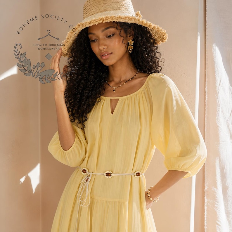 Yellow boho midi dress for women featuring lightweight Tencel fabric, romantic puff sleeves, flowing A-line silhouette, and adjustable lace-up waist detail. Feminine cottagecore summer dress with soft airy texture and relaxed fit perfect for brunch dates, vacations, garden parties, tea parties, casual chic styling, and everyday elegance. Pastoral-inspired midi dress in buttery yellow tone designed for breathable comfort and graceful movement during spring and summer wear.