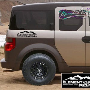 May include: A two-tone SUV with a black tire and rim. The vehicle has a black mountain graphic with the text "ELEMENT OFF ROAD" on the side. A black and white logo with the same text is at the bottom.