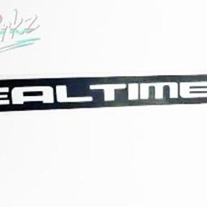 Puede incluir: Una pegatina rectangular negra con las palabras "REAL TIME 4WD" en letras blancas. La pegatina también tiene un logotipo en la esquina superior izquierda y el texto "Boosted Bikz EST. 2020".