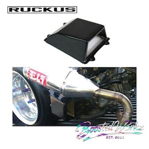 May include: Black rectangular automotive part with the word "RUCKUS" in a white font. Below is a close-up of a motorcycle exhaust system with a silver muffler and the text "Yoshimura" in red.