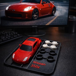 May include: A white ceramic mug with a black handle and the text "But First, Coffee" in a bold, black font. The mug is set against a neutral background, highlighting its simple design.