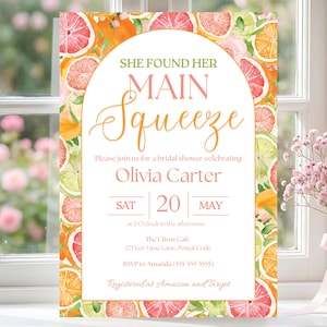 May include: A bridal shower invitation with a citrus fruit design. The invitation features the text "She Found Her Main Squeeze" and details for Olivia Carter's shower, including the date, time, and location. The invitation is framed by watercolor illustrations of oranges, grapefruits, and limes.