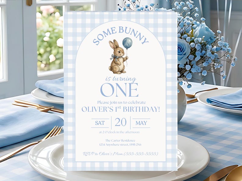K&ouml;nnte beinhalten: Eine hellblaue und wei&szlig;e karierte Einladungskarte mit dem Text "SOME BUNNY is turning ONE". Die Karte zeigt eine Aquarellillustration eines Hasen mit einem Ballon. Die Einladung ist f&uuml;r Olivers 1. Geburtstag.