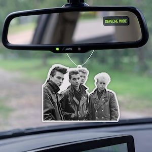 以下が含まれることがあります： 車のバックミラーから吊り下げられた、Depeche Modeの芳香剤。芳香剤には、バンドメンバーの白黒画像が描かれています。バックミラーには「DEPECHE MODE」の文字が表示されています。