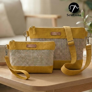 May include: Two handmade bags in mustard yellow and gray. The smaller bag has a wrist strap, and the larger bag has a shoulder strap. Both bags have a rectangular shape with a zipper closure and a small "handmade" tag.