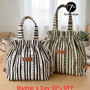 May include: Two drawstring bags with striped patterns. One is black and white, the other is olive green and white. Both have a small pocket and a "handmade" tag. The bags have wooden bead accents and handles. The text "Mother's Day 50% OFF" is at the bottom.