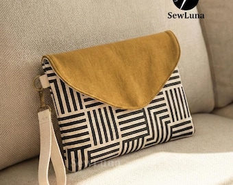 May include: A clutch with a mustard-colored flap and a black and white geometric pattern. It has a cream-colored wrist strap and a gold-colored clasp. The SewLuna logo is visible in the upper right corner.
