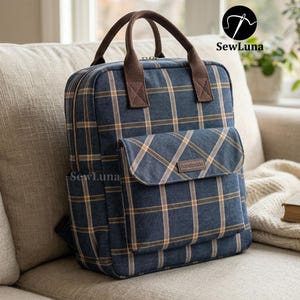 Peut inclure: Sac à dos à carreaux bleus avec des accents marron, y compris les poignées et une poche avant. Le sac à dos a une fermeture éclair et une petite étiquette "handmade". Le logo "SewLuna" est visible.