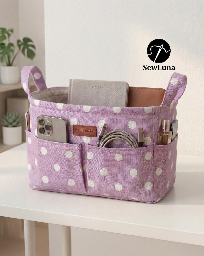Purple polka dot handmade fabric purse organizer bag filled with daily essentials like a hairbrush, hand cream, and keys. A PDF sewing pattern project for a bag insert or desk storage bin displayed on a clean white background.