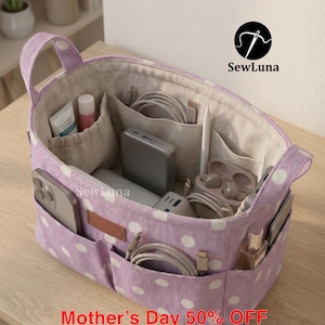 Könnte beinhalten: Eine lila-weiß gepunktete Organizer-Tasche mit mehreren Fächern, Griffen und einem hellen Innenraum. Die Tasche enthält verschiedene Gegenstände, darunter ein Telefon, ein Ladegerät und Kosmetika. Der Text "SewLuna" und "handmade" sind sichtbar.