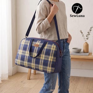 Puede incluir: Un bolso de viaje rectangular con un patrón de cuadros azules y amarillos, paneles laterales azul marino, asas azul marino y una correa de hombro ajustable. Una pequeña etiqueta rectangular marrón está centrada en la parte frontal. El logo SewLuna es visible.